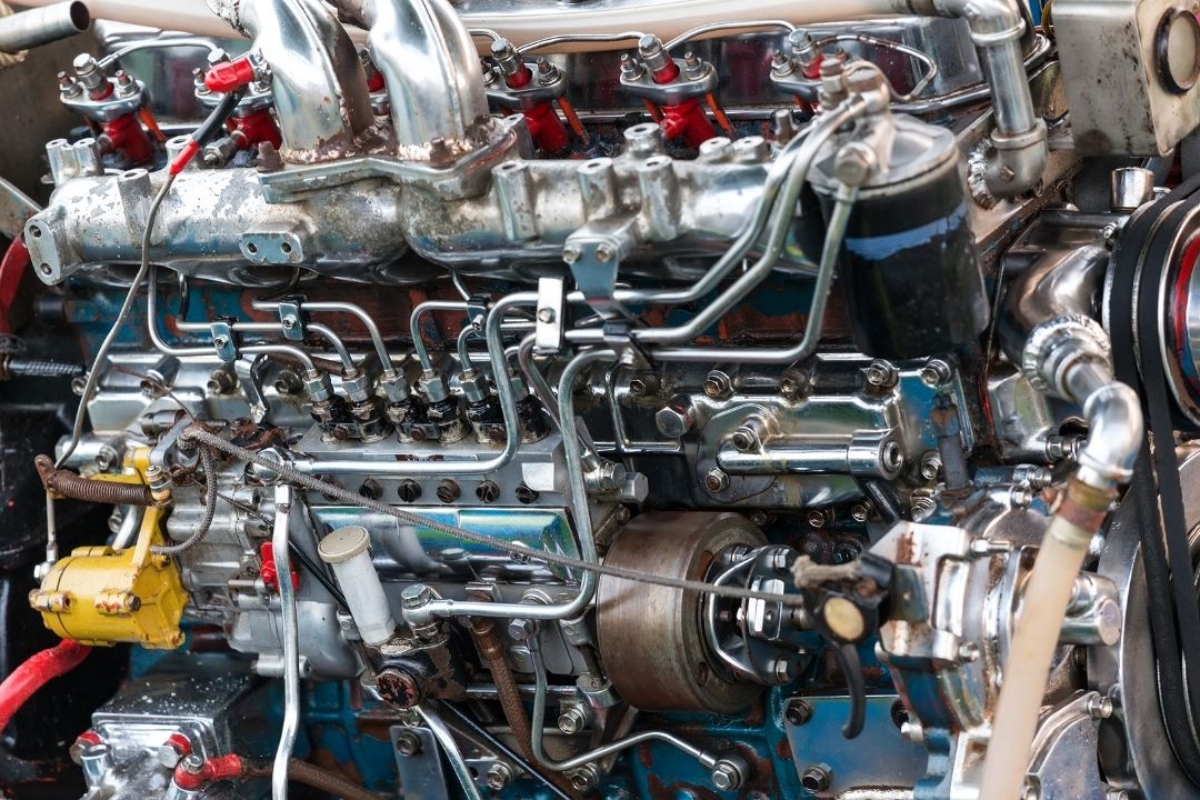 Close-up view of a complex diesel engine, highlighting metallic components, pipes, fuel injectors, and wires—perfect for showcasing the expertise of diesel mechanical services on worn and slightly rusty mechanical parts.